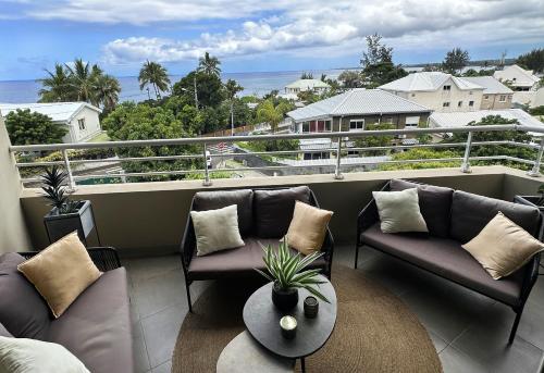 - un balcon avec deux canapés et une table avec vue dans l'établissement Melody, à Saint-Paul