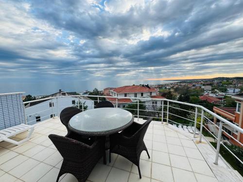 een patio met een tafel en stoelen op een balkon bij İstanbul Airport Treekos Suite Hotel in Karaburun