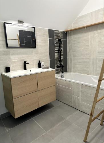 une salle de bain avec un lavabo et une baignoire dans l'établissement Melody, à Saint-Paul