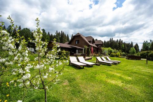 a group of lounge chairs sitting in a yard at Penzion Sileo in Pribylina