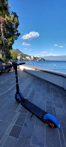 a scooter parked on a sidewalk next to the water at Pizzocolo resort fasano in Gardone Riviera
