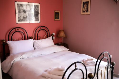 een slaapkamer met een wit bed met rode muren bij CHOPIN in Patra