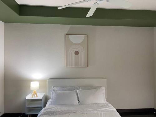 ein Schlafzimmer mit einem weißen Bett und einem Bild an der Wand in der Unterkunft Chic and Modern unit in Los Angeles