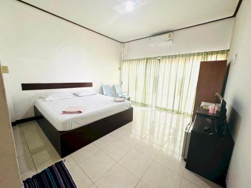 um pequeno quarto com uma cama e um chuveiro em OYO 75484 My Home Guesthouse em Ban Bang Saen (1)
