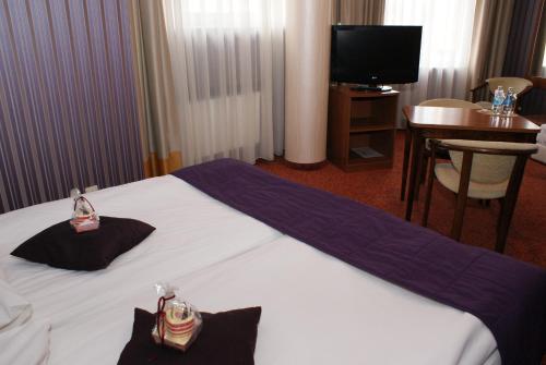 En eller flere senge i et værelse på Grot Hotel
