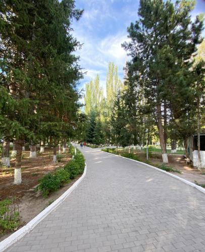 un camino de ladrillo en un parque con árboles en Ай хаус, en Cholpon-Ata