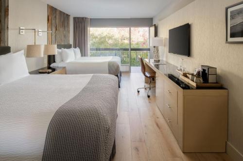 サンタクルーズにあるホテル パラドックスのベッド2台とテレビが備わるホテルルームです。