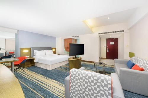 a hotel room with a bed and a tv at Holiday Inn Express City Centre Dalian by IHG in Dalian