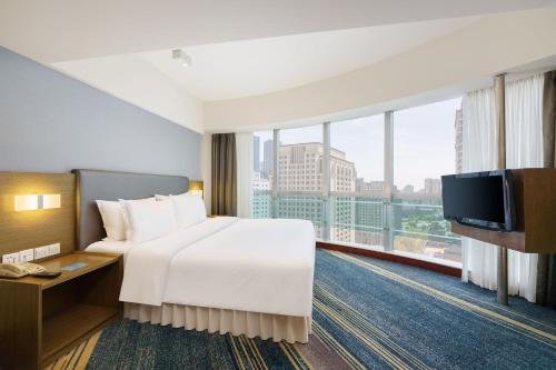 a hotel room with a bed and a tv at Holiday Inn Express City Centre Dalian by IHG in Dalian