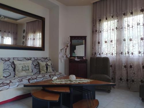 a living room with a couch and a table and a mirror at SUN GARDEN in Skala Sotiros