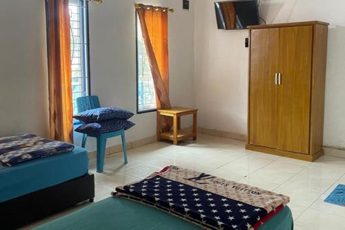 a room with two beds and a cabinet at OYO 93849 Kng Homestay Syariah in Pekanbaru