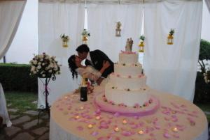 a bride and groom cutting their wedding cake at Hotel Holiday Sul Lago in Bolsena