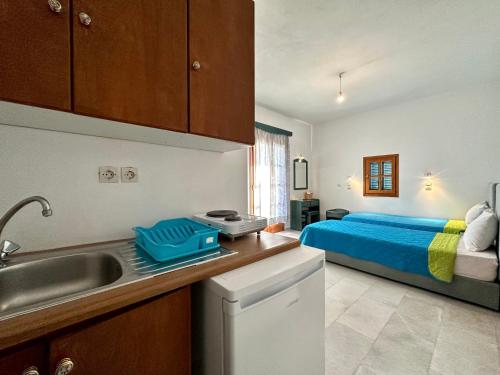 una cocina con fregadero y una cama en una habitación en Nostos Plaka Beach en Plaka