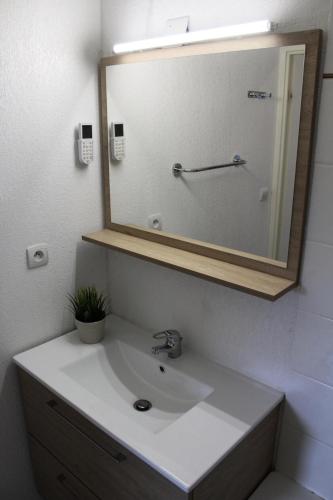 une salle de bain avec un lavabo blanc et un miroir dans l'établissement Résidence Les Chaumettes - TRES BEL APPARTEMENET ENTIEREMENT RENOVE MAE-0124, à Saint-Étienne-en-Dévoluy