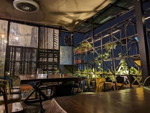 a restaurant with tables and chairs and a wall with plants at Astra Hotels & Suites - HSR Layout Sector 1, Near Ecospace Bellandur in Bengaluru