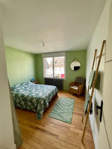 une chambre avec un lit, une chaise et une fenêtre dans l'établissement Charmante maison de ville, à Saint-Brieuc