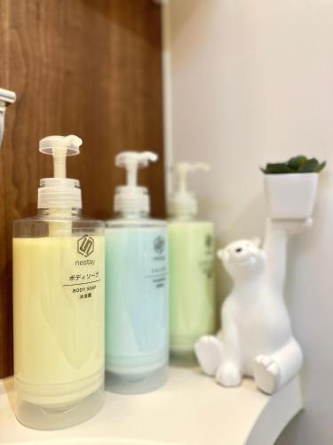 a bathroom counter with two bottles of soap and a stuffed animal at nestay東九条02右側 in Kyoto