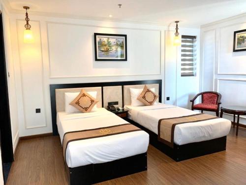 a hotel room with two beds and a table at Phong Nha Jasmine Hostel & Roof Top Bar in Phong Nha