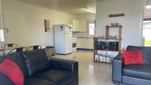 een woonkamer met een bank en een keuken bij Lowset home with attached Granny Flat - Doomba Dr, Bongaree in Bongaree