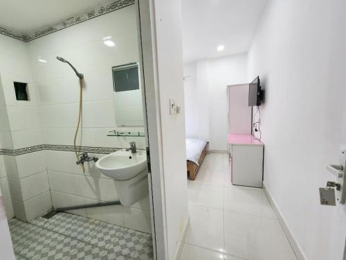 a white bathroom with a sink and a shower at Dlux Bùi Văn Thêm in Ho Chi Minh City