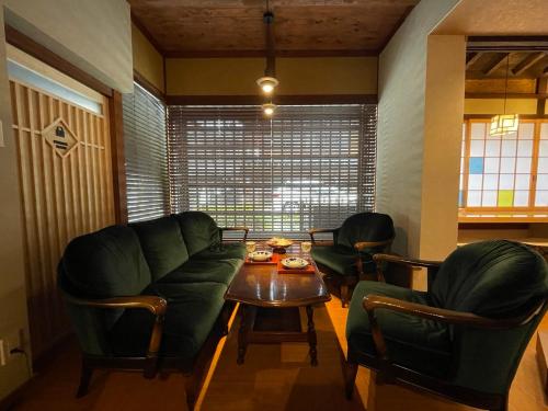 a living room with a couch and a table and chairs at 游　別邸　飛騨高山　狐福 in Takayama