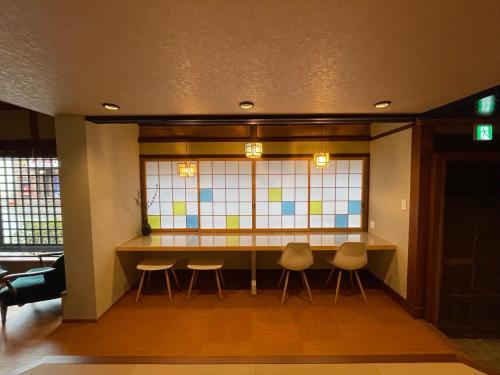 a room with a table and chairs and a stained glass window at 游　別邸　飛騨高山　狐福 in Takayama