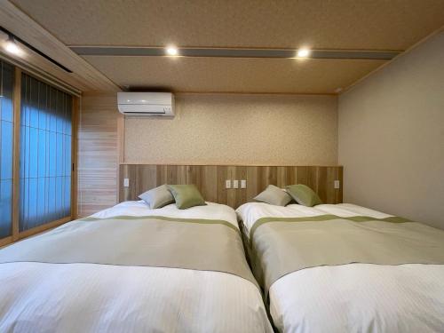 a room with two beds in a room with a window at 游　別邸　飛騨高山　狐福 in Takayama