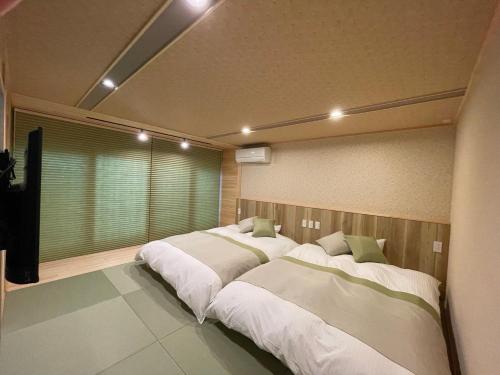 two beds sitting in a room with at 游　別邸　飛騨高山　狐福 in Takayama