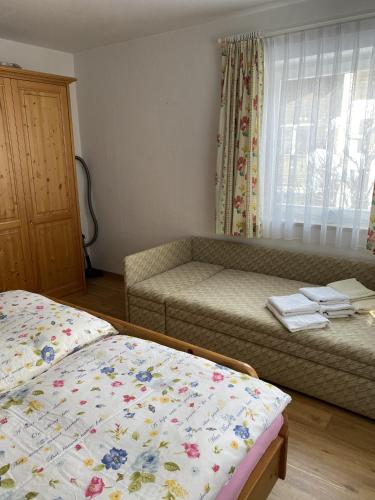 Zimmer mit einem Bett, einem Sofa und einem Fenster in der Unterkunft Wohnung mit Bergblick in Mittenwald in Mittenwald