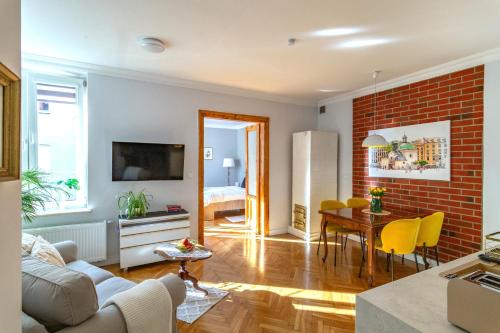 a living room and dining room with a brick wall at Smile Apartments Center Kraków Old Town in Krakow