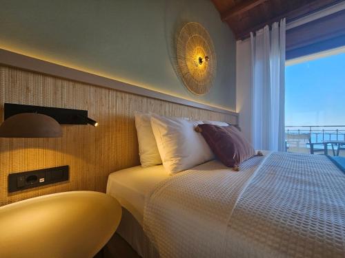 a bedroom with a bed with a view of the ocean at Yialasi Hotel in Ancient Epidavros
