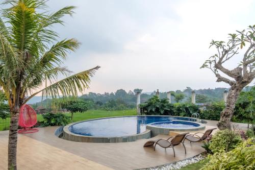 basen z krzesłami i palmą w obiekcie TwoSpaces Living at deRos Resort & Cafe, Bogor w mieście Ciherangsating