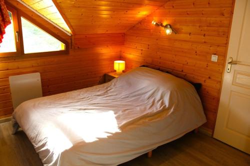 a bedroom with a bed in a wooden cabin at Les Chalets Margot - Chalets pour 6 Personnes 651 in Le Dévoluy
