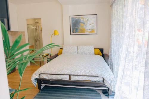 sypialnia z łóżkiem i rośliną w obiekcie Appartement avec jardin w mieście Bègles