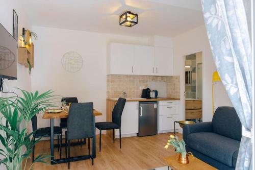 une cuisine et un salon avec une table et un canapé dans l'établissement Appartement avec jardin, à Bègles