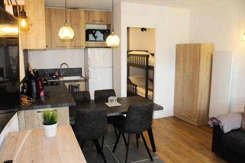 a kitchen and living room with a table and chairs at Résidence Le Bois D'aurouze - Studio pour 4 Personnes 701 in Le Dévoluy