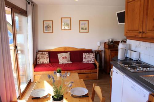 een keuken met een tafel en een bed in een kamer bij Les Chalets De Superd Ancolie - 2 Pièces pour 6 Personnes 741 in Le Dévoluy