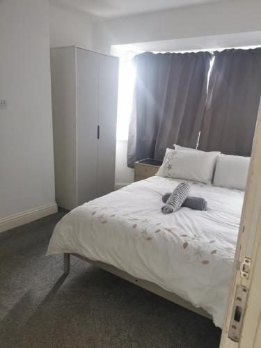 1 dormitorio con 1 cama blanca grande y cabecero en Deluxe Double Room Cosy and Comfortable FFDBL7 en Barking