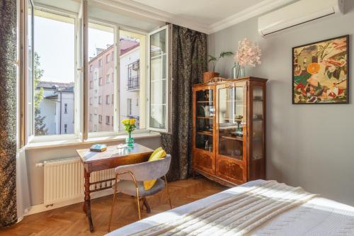 een slaapkamer met een bureau, een bed en een raam bij Smile Apartments Center Kraków Old Town in Krakau
