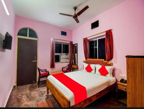 um quarto com uma cama com um edredão vermelho e branco em Hotel Planet 9 Puri - Wonderfull Stay with Family Near Sea Beach em Puri