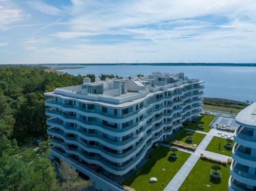 an aerial view of a large building next to a body of water at Rogowo Pearl Apartamenty in Rogowo