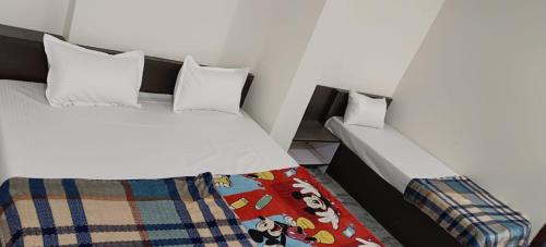 1 dormitorio con 2 camas y 1 manta en G GUEST HOUSE en Gorakhpur