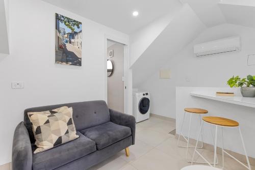 a living room with a couch and a table at Modern & Bright Inner-City Studio Apartment in Sydney