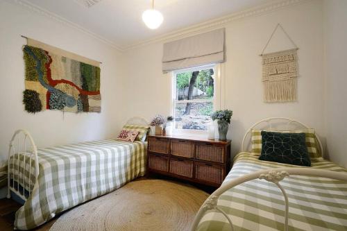 1 dormitorio con 2 camas y ventana en Harrys House Warburton - Peaceful Riverside cottage in the perfect location, en Warburton