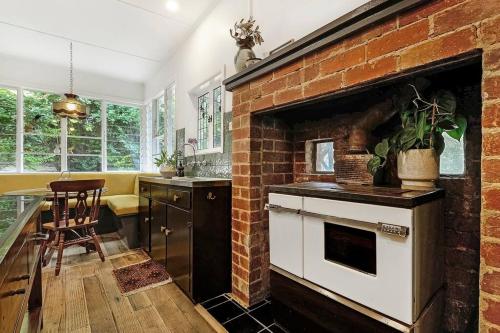 cocina con pared de ladrillo y horno en Harrys House Warburton - Peaceful Riverside cottage in the perfect location, en Warburton