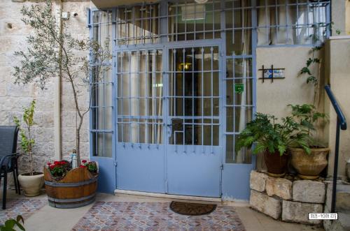 a blue door in a building with plants at Alexandra House in Nazareth