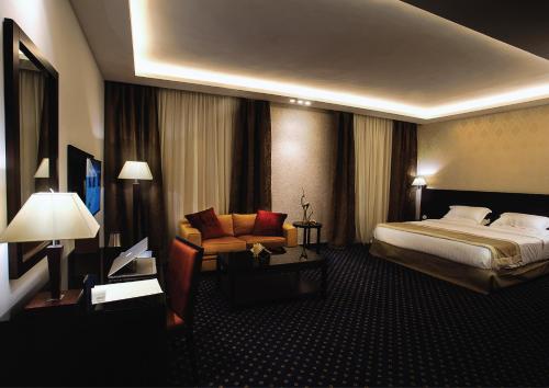 Pokój hotelowy z łóżkiem i krzesłem w obiekcie فندق سفن روزز w mieście Amman