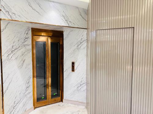 a hallway with a door in a white wall at Hotel IP Swarn near Anand Vihar Vaishali Ghaziabad in Ghaziabad
