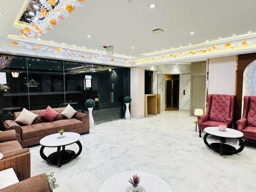 a lobby with couches and tables in a building at Hotel IP Swarn near Anand Vihar Vaishali Ghaziabad in Ghaziabad