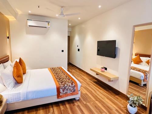 a hotel room with a bed and a flat screen tv at Hotel IP Swarn near Anand Vihar Vaishali Ghaziabad in Ghaziabad